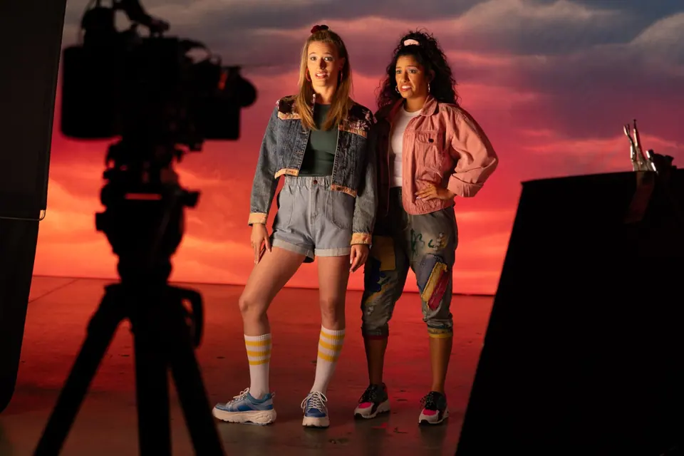 Cinema camera framing two Back to the 80s performers against a sunset backdrop