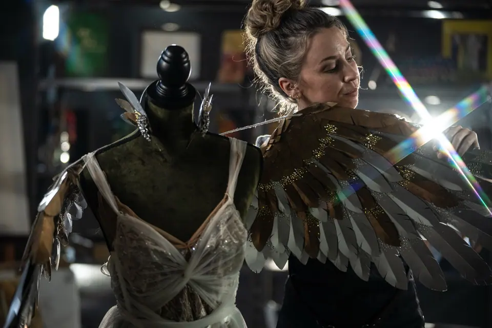 Costume artisan adjusting a practical character wing by hand